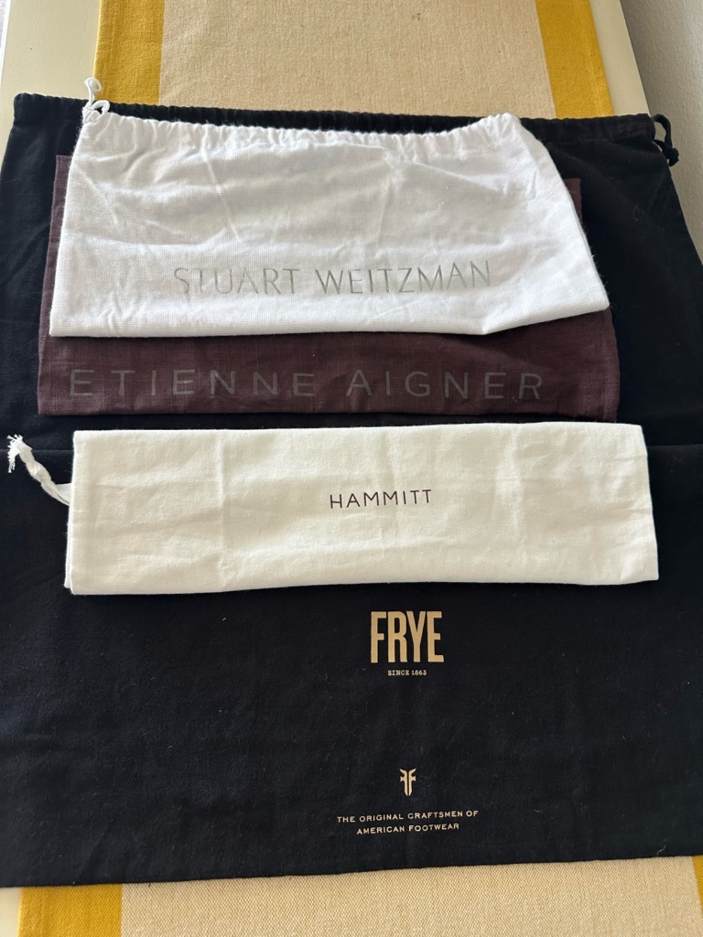 Frye, Etienne Aigner, Stuart Weitzman, Hammitt white drawstring pouch.